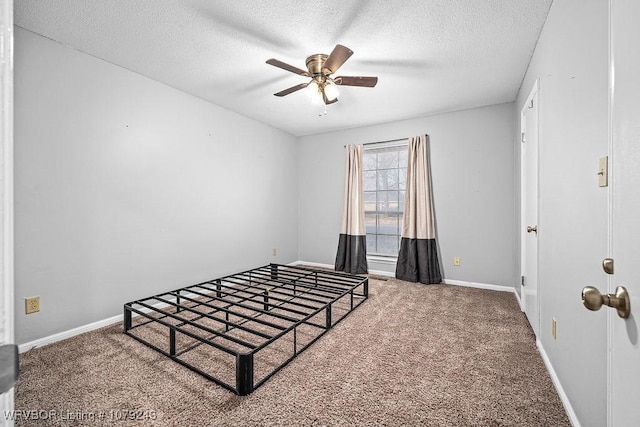 bedroom featuring a textured ceiling, carpet, a ceiling fan, and baseboards