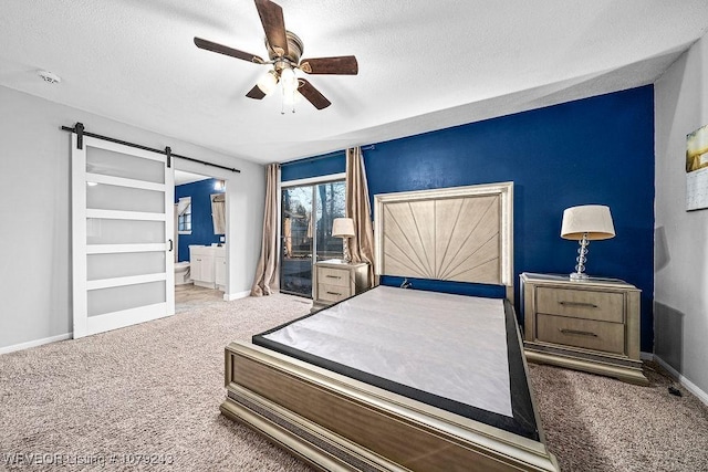 carpeted bedroom featuring a textured ceiling, baseboards, and a barn door