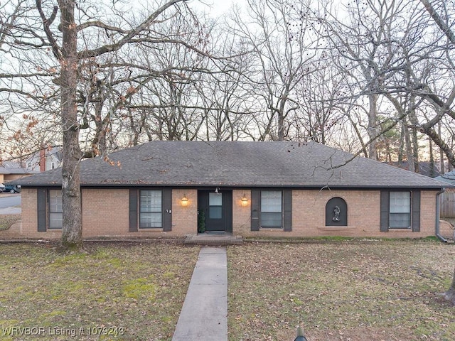 view of front of home featuring a shingled roof and brick siding