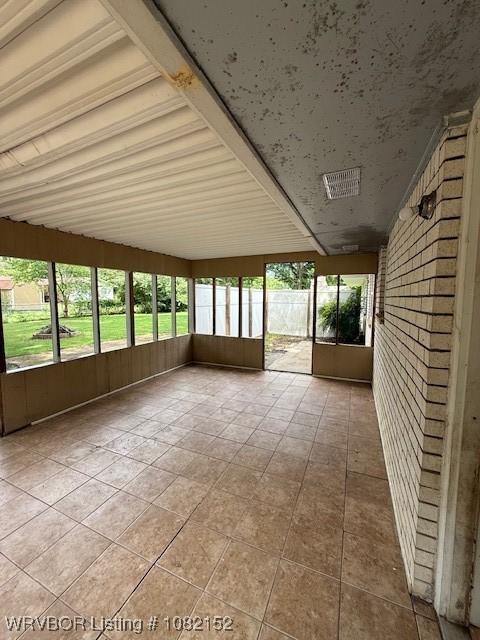 503 E Mayo Dr, Sallisaw, OK 74955 - unfurnished sunroom with wood walls, tile patterned floors, and healthy amount of natural light