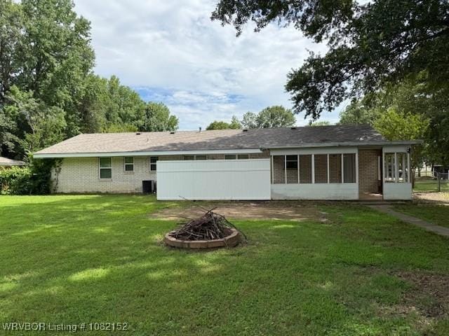 503 E Mayo Dr, Sallisaw, OK 74955 - back of property featuring a fire pit, a lawn, and brick siding
