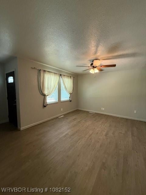 503 E Mayo Dr, Sallisaw, OK 74955 - spare room featuring a textured ceiling, ceiling fan, and wood finished floors