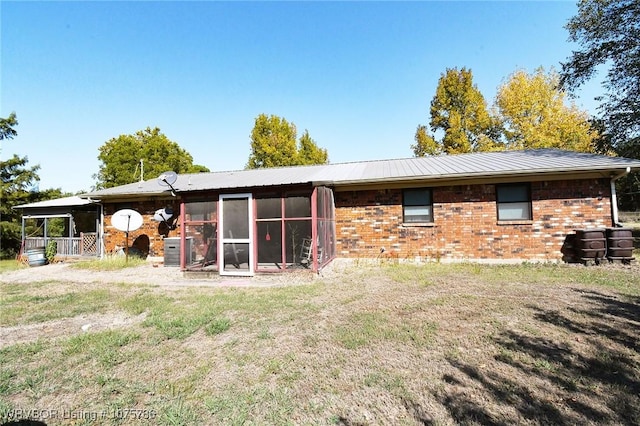 rear view of property with a sunroom