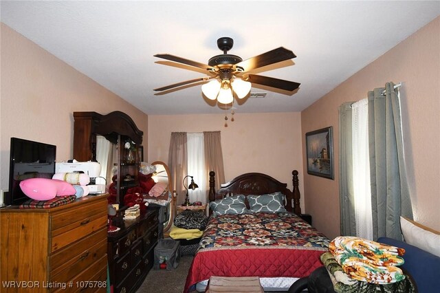 carpeted bedroom with multiple windows and ceiling fan