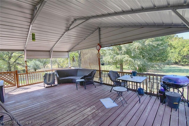 wooden deck with an outdoor living space and area for grilling