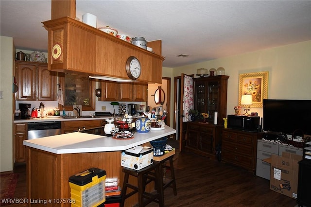 kitchen featuring stainless steel dishwasher, dark hardwood / wood-style floors, kitchen peninsula, and sink