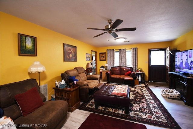 living room with ceiling fan and light hardwood / wood-style flooring