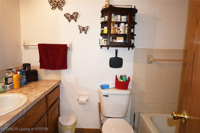 bathroom featuring a tub, vanity, and toilet