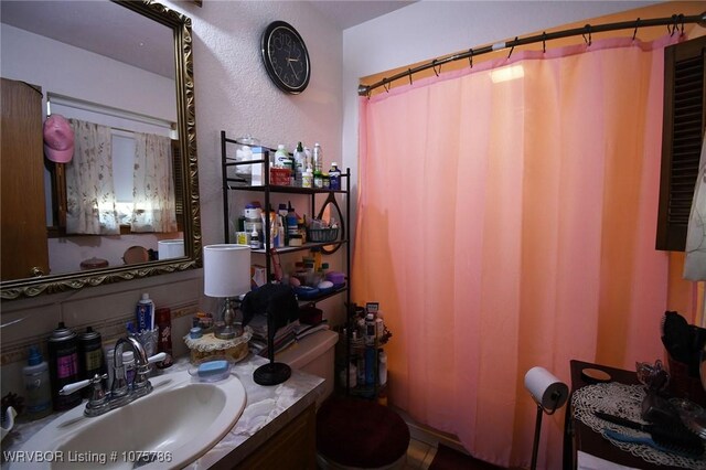 bathroom featuring a shower with shower curtain, vanity, and toilet