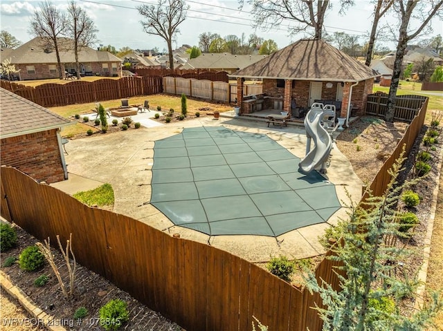 view of pool with a fenced backyard, a residential view, an outdoor structure, and a patio area