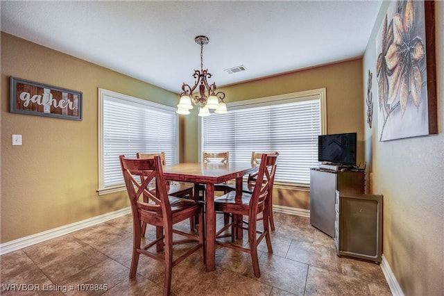 dining area with baseboards, visible vents, and a chandelier