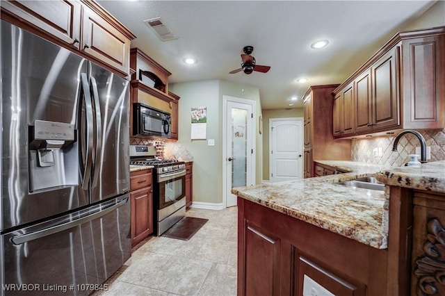 kitchen with visible vents, ceiling fan, light stone countertops, stainless steel appliances, and a sink