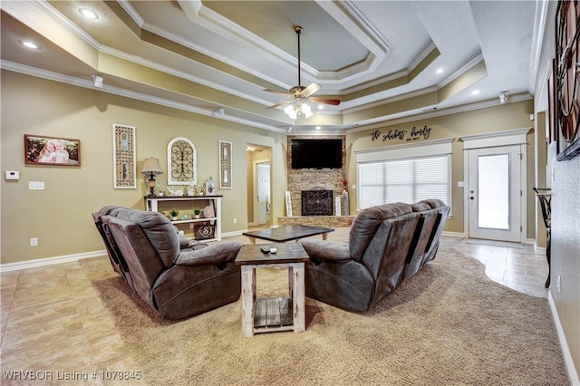 living room with tile patterned flooring, baseboards, a raised ceiling, ceiling fan, and a fireplace