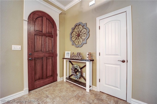 foyer with crown molding and baseboards