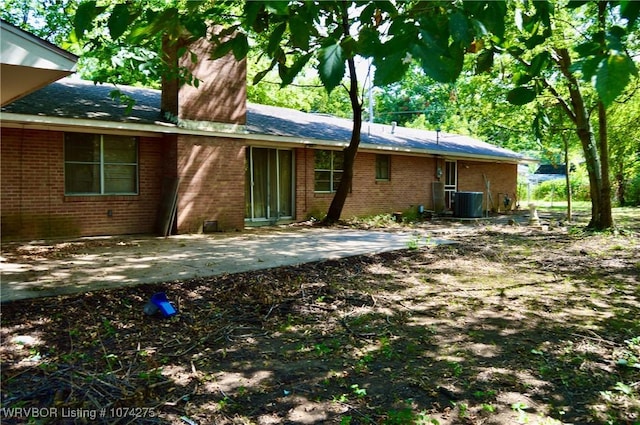 back of property with central AC unit and a patio area