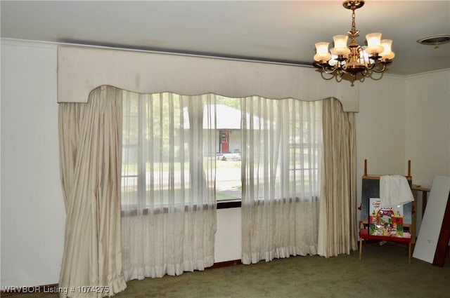 carpeted spare room featuring a chandelier and a wealth of natural light