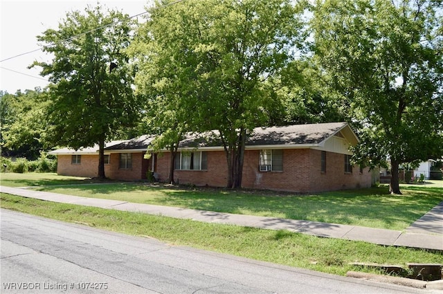 ranch-style house featuring cooling unit and a front lawn