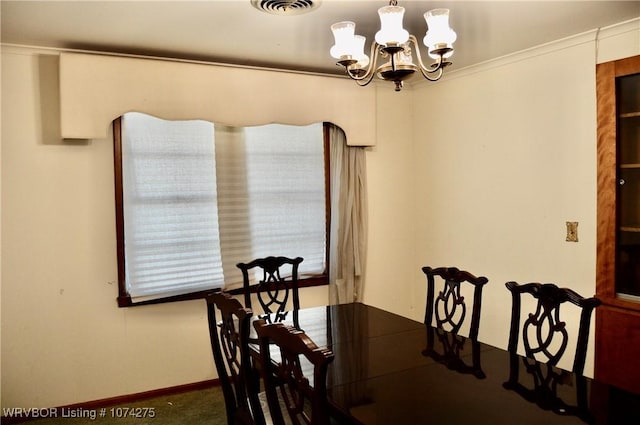 carpeted dining space with crown molding and a chandelier