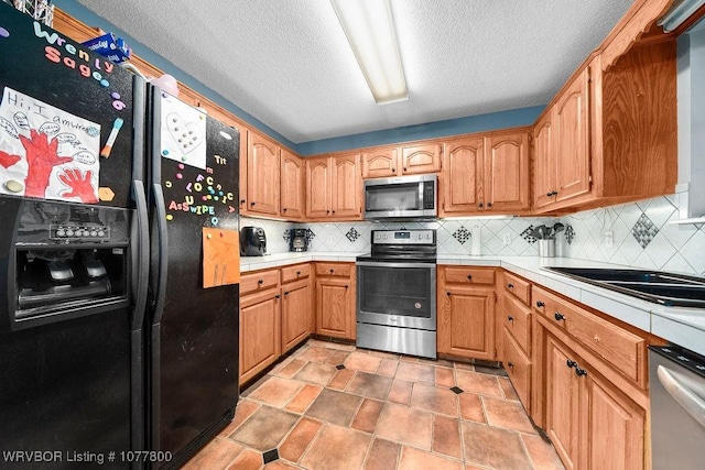 kitchen with tasteful backsplash, a textured ceiling, and appliances with stainless steel finishes