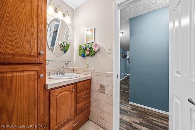 bathroom featuring vanity, wood-type flooring, and tile walls