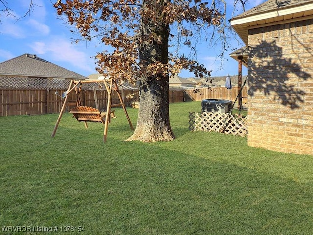 view of yard with a fenced backyard and a playground