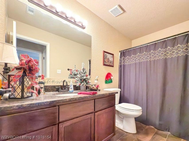 bathroom with toilet, visible vents, a textured ceiling, and vanity