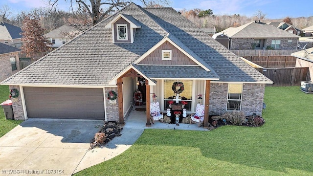 view of front of house featuring driveway, a garage, fence, and a front lawn