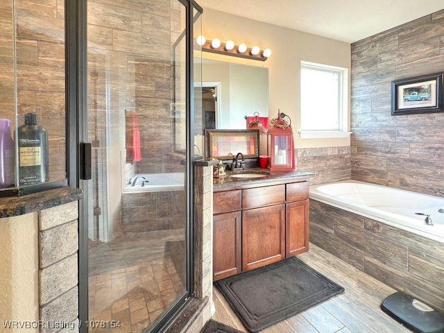 bathroom featuring a shower stall, vanity, and a bath