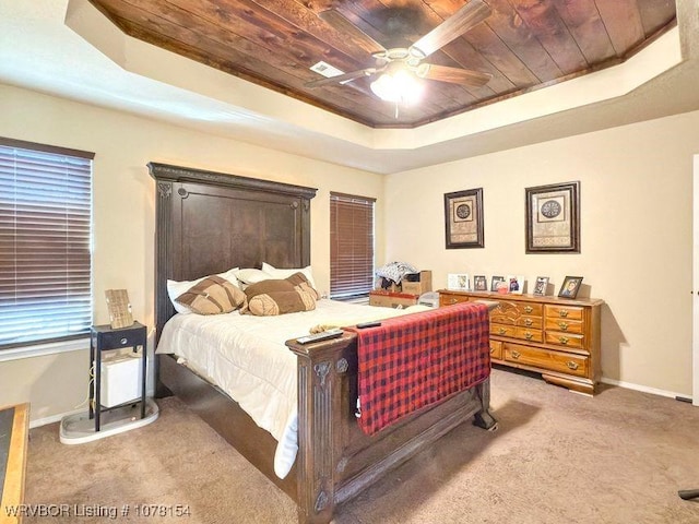 bedroom with a tray ceiling, carpet, ceiling fan, wooden ceiling, and baseboards