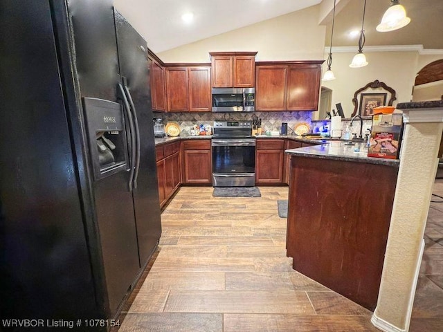 kitchen with tasteful backsplash, appliances with stainless steel finishes, decorative light fixtures, light wood-style floors, and a sink