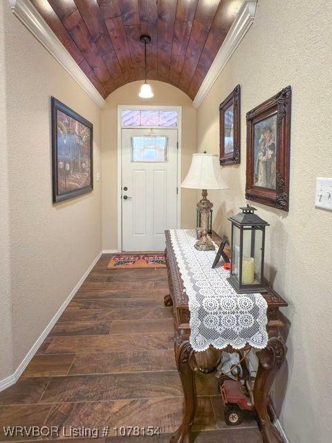 doorway to outside featuring dark wood-style floors, lofted ceiling, and baseboards