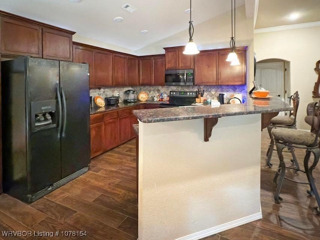 kitchen featuring arched walkways, pendant lighting, a breakfast bar area, visible vents, and black appliances