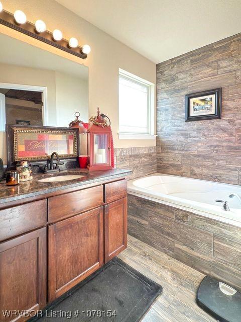 full bathroom with a garden tub and vanity