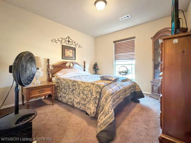 carpeted bedroom with a textured ceiling and visible vents