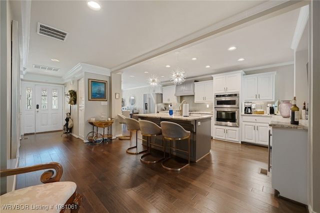 5701 Free Ferry Rd Unit 12, Fort Smith, AR 72903 - kitchen with crown molding, appliances with stainless steel finishes, white cabinets, a kitchen bar, and dark wood-type flooring