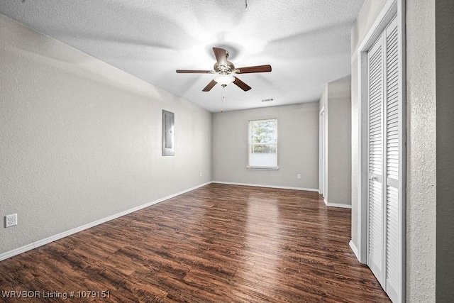 unfurnished bedroom with dark wood-style floors, visible vents, a textured ceiling, and baseboards