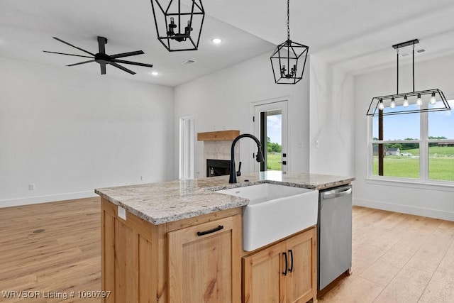 1317 Big Oak Dr, Alma, AR 72921 - kitchen with light wood-style flooring, a sink, a tiled fireplace, baseboards, and dishwasher