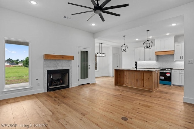 1317 Big Oak Dr, Alma, AR 72921 - kitchen with visible vents, open floor plan, a ceiling fan, stainless steel range, and light wood-style floors