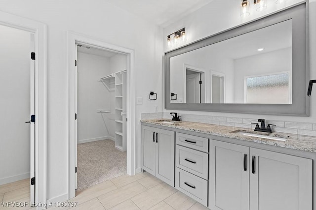 1317 Big Oak Dr, Alma, AR 72921 - bathroom with a sink, a walk in closet, double vanity, and baseboards