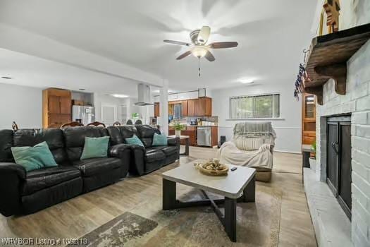 204 Cornell Ave, Fort Smith, AR 72908 - living area featuring a fireplace with raised hearth, a ceiling fan, and light wood-style flooring