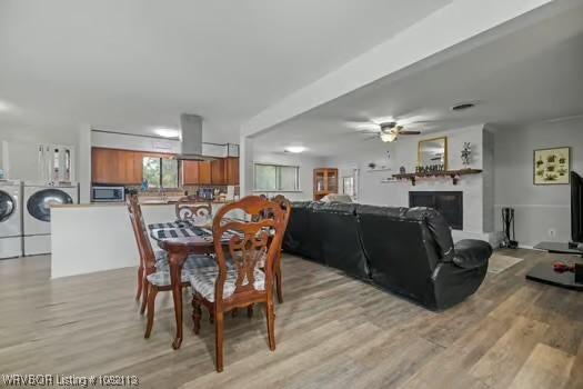 204 Cornell Ave, Fort Smith, AR 72908 - dining room with independent washer and dryer, light wood finished floors, ceiling fan, and a glass covered fireplace