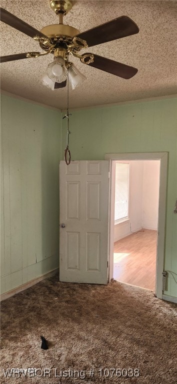 carpeted empty room with a textured ceiling and ceiling fan