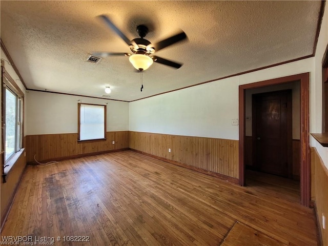 1100 Dechard St, Van Buren, AR 72956 - unfurnished room with wainscoting, wood finished floors, a textured ceiling, wooden walls, and a ceiling fan