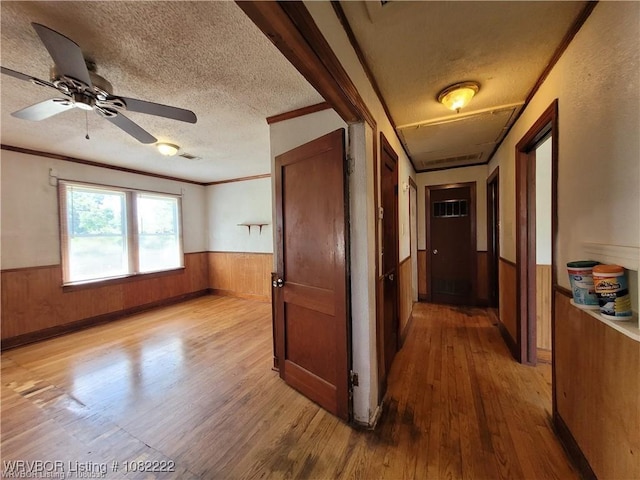 1100 Dechard St, Van Buren, AR 72956 - hallway featuring a wainscoted wall, wood finished floors, wooden walls, a textured ceiling, and ornamental molding
