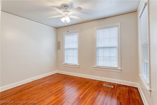 spare room featuring visible vents, light wood-style flooring, baseboards, and a ceiling fan