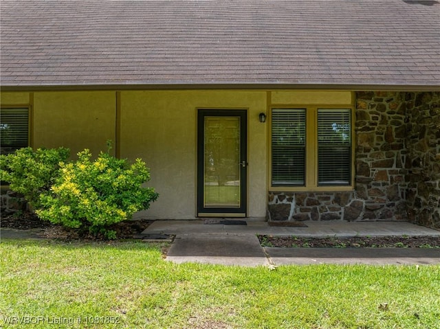 3232 Edinburgh Dr, Fort Smith, AR 72908 - doorway to property featuring stone siding, a lawn, roof with shingles, and stucco siding