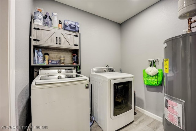 614 12th St, Van Buren, AR 72956 - laundry room featuring water heater, cabinet space, independent washer and dryer, light wood finished floors, and baseboards