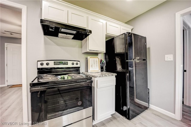 614 12th St, Van Buren, AR 72956 - kitchen with stainless steel electric stove, range hood, freestanding refrigerator, and light wood-type flooring