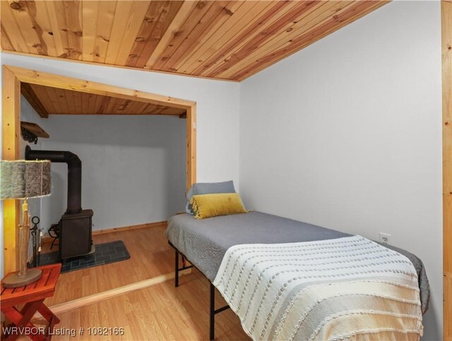 33971 Holson Valley Rd, Wister, OK 74966 - bedroom with wood ceiling, wood finished floors, and a wood stove