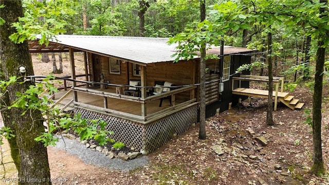 33971 Holson Valley Rd, Wister, OK 74966 - rear view of property featuring a wooden deck, a metal roof, and a wooded view